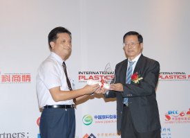 Kaymond Chow (left), Arburg  sales consultant from the Shenzhen office, accepted the award for the new and innovative hybrid high precision machine Allrounder Hidrive from the hands of panel member Chen Xinjie, General Secretary of the Shantou Plastic Commerce Committee.
