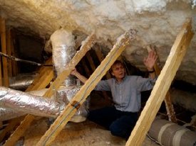 ORNL�s Jeff Christian points out the insulating foam used to seal the attic in a deep retrofit house. 
