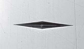 A Knoop indentation, as it appears on a smoothly polished surface, showing good tip definition.