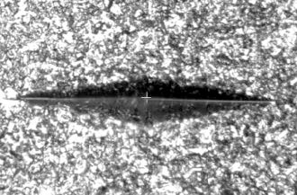 Knoop indentation, as it appears on an etched surface, showing poor tip definition - especially comparing the right side to the left