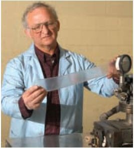 Larry Bourland, CEO of PolyVISIONS Inc. inspects quality of extruded profile.