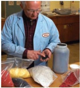 Larry Bourland demonstrates PolyVISIONS finished specialty additive products in pellet form
