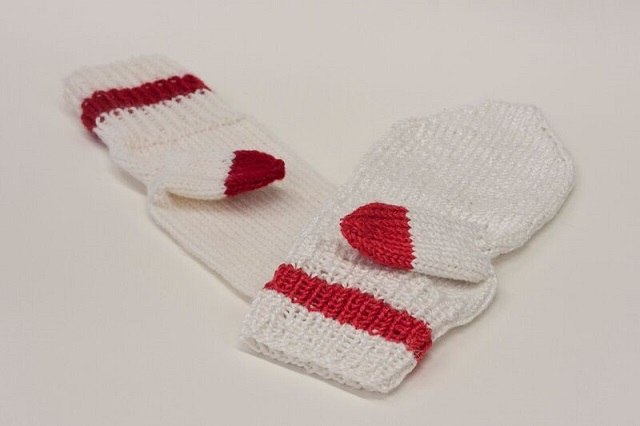 A prototype mitten made from the yarn on the right, next to one made from merino wool.