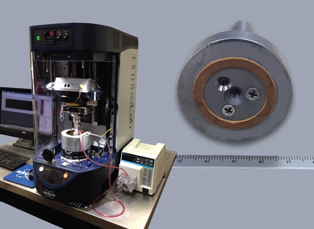 The UMT TriboLab benchtop tribotest system used in the simulation of clutch material testing, and detail of sub-scale clutch material sample (ruler in cm).