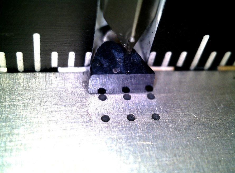 The SmB6 sample is approximately 4 mm in width and 1 mm in height, with both cleaved [001] planes. It is sliced from the ingot; the curved side is the perimeter of the ingot. Using the optical microscope and computer display, it is possible to confirm the shape and dimension for the slice of the material.