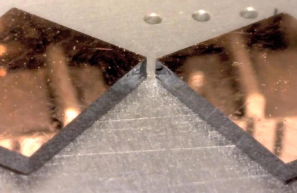 Copper film on (100) silicon cleaved after making a short scribe. Cleaved edge shows mirror finish.