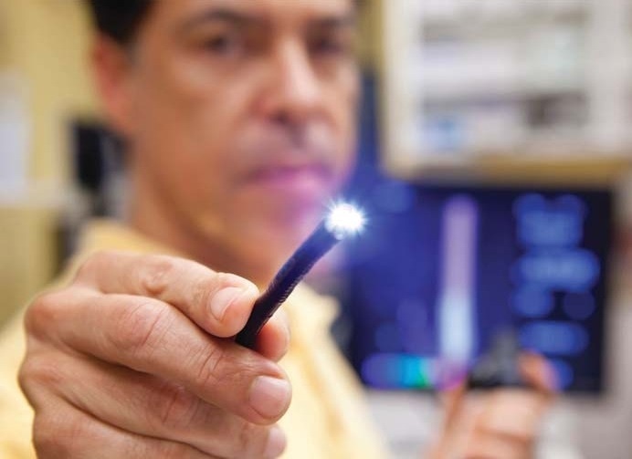 A doctor holds a lighted probe used in endoscopic procedures.