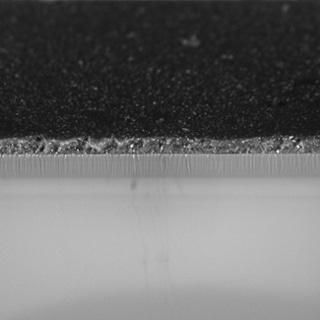 Glass sheet coated with different materials. The multiple layers add specific properties to the product.