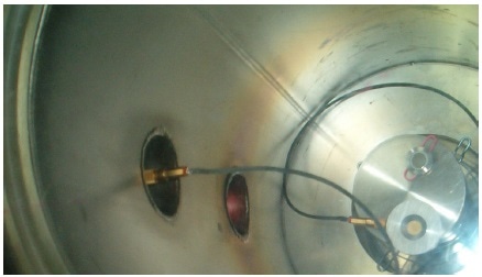 Interior of Chamber #1 showing Evactron plasma pink glow during Evactron cleaning exposure of window #5. A quartz thin film thickness monitor is also shown in chamber placed on pedestal beside window.