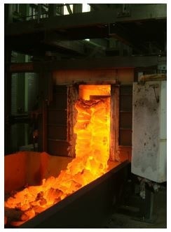 Moving wall coke oven discharging.