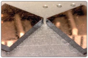 Copper film on (100) silicon cleaved after making a short scribe. Cleaved edge shows mirror finish.