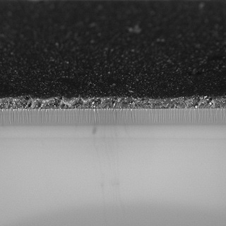 Glass sheet coated with different materials. The multiple layers add specific properties to the product.