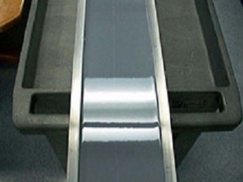 Finished epoxy surface on calibration beam reflecting the overhead florescent lighting fixture
