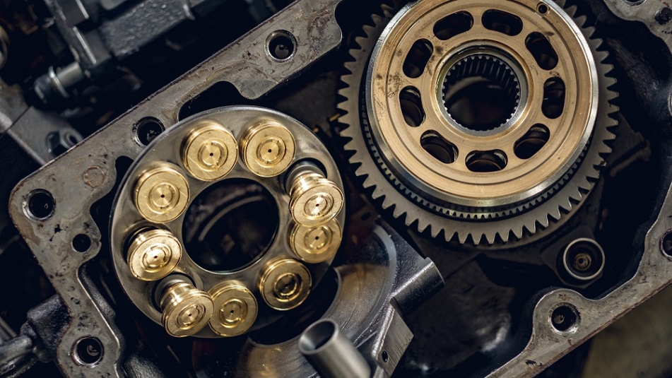 A service technician repairs a damaged hydraulic pump. Professional power hydraulics workshop. Hydraulic motor folding