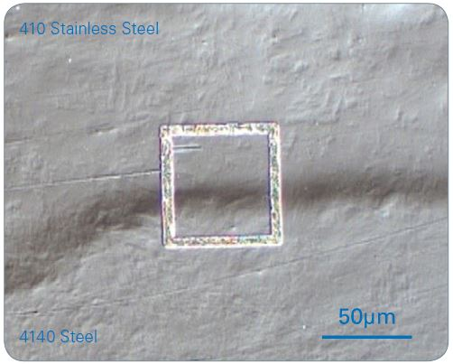 An optical micrograph of a cross-section of a 410 stainless steel/4140 steel laser beam welded interface. Nanoindentation was carried out within the focused ion beam (FIB) ablated square. Note: The nanoindentation grid is not visible.