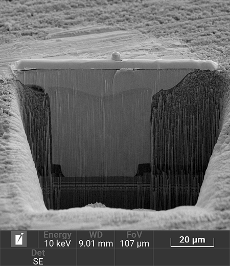 100 um wide Plasma FIB cross-section through solder bump and copper µVIA. The interface is partially covered by curtaining artifacts making it difficult for failure analysis. FIB milling time 50 minutes.