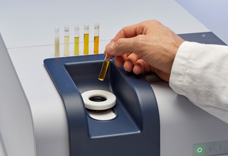 The glass vial filled with oil is placed in the sample compartment of the spectrometer.