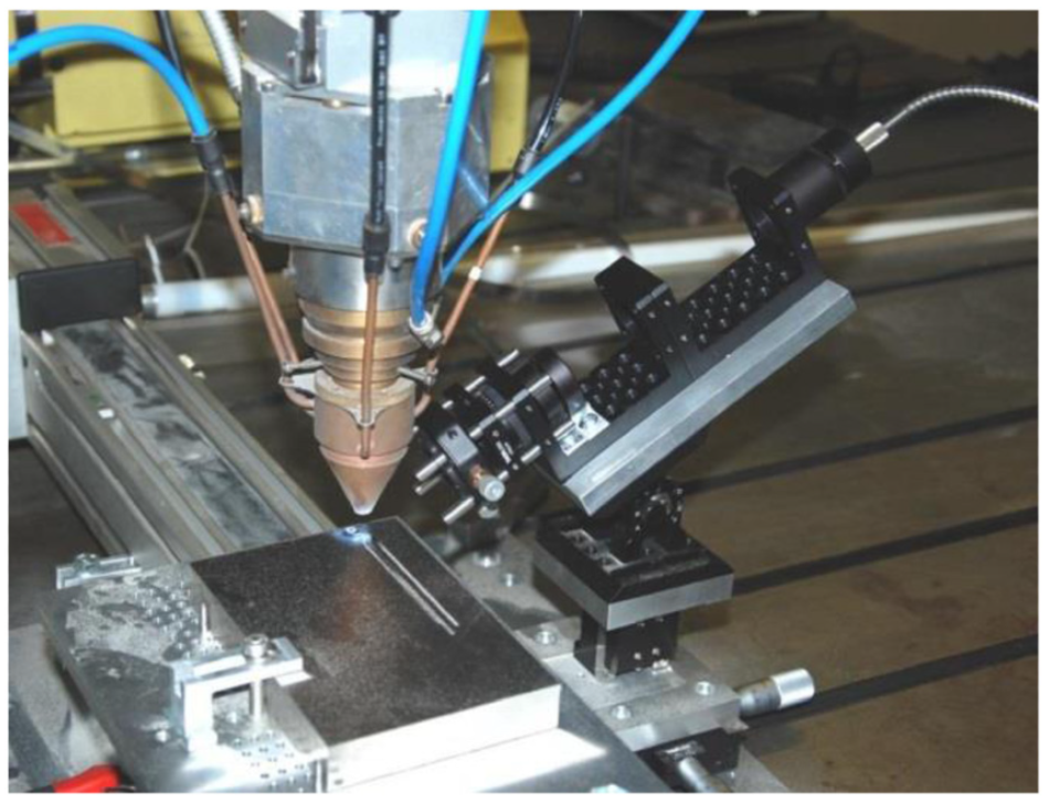 Picture of fiber-optic cable and collection optics integrated into DED printing head [3].