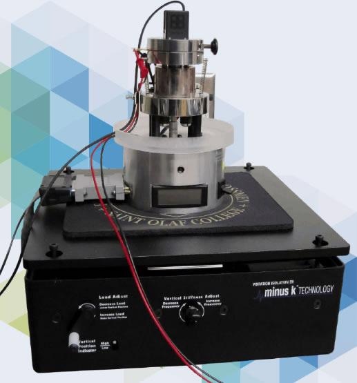The nanoindenter-quartz microbalance mounted on a negative-stiffness vibration isolator