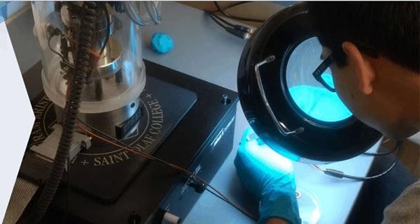 A researcher performing a nanotribology experiment using the nanoindenter-quartz microbalance.