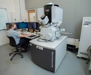 EMC user at the controls of the Helios NanoLab 660 FIB-SEM.