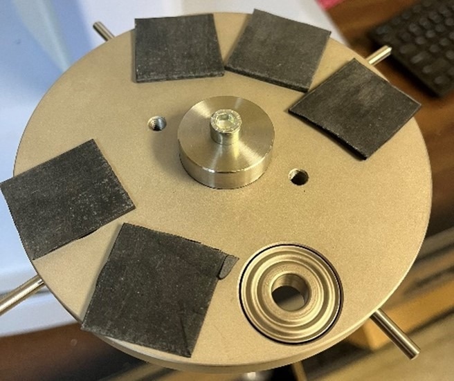 This shows the polychloroprene samples being loaded into the lower support for the validation testing