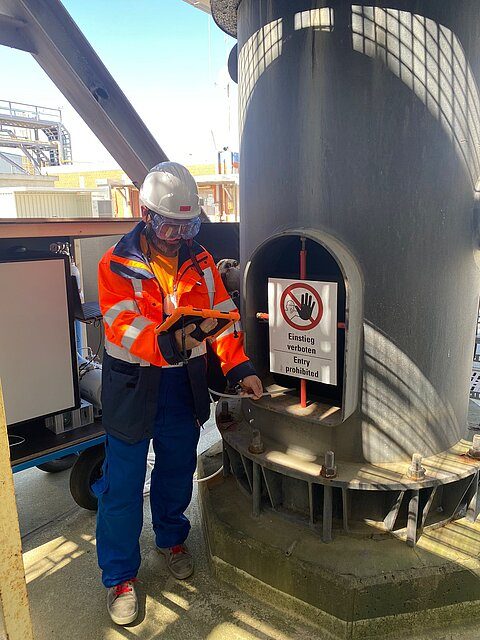 Operator checking a manhole for emissions using the live data streamed to a tablet display from the mobile PTR-TOF instrument