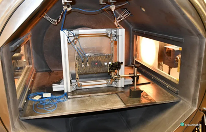 Back of the photovoltaic element aligned in the bombardment chamber. Deflection mirrors guide the measuring beams of the vibrometers, which are guided through the viewing windows, onto the target sample