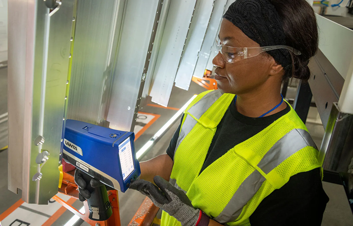 A technician performs coating analysis using a handheld XRF analyzer