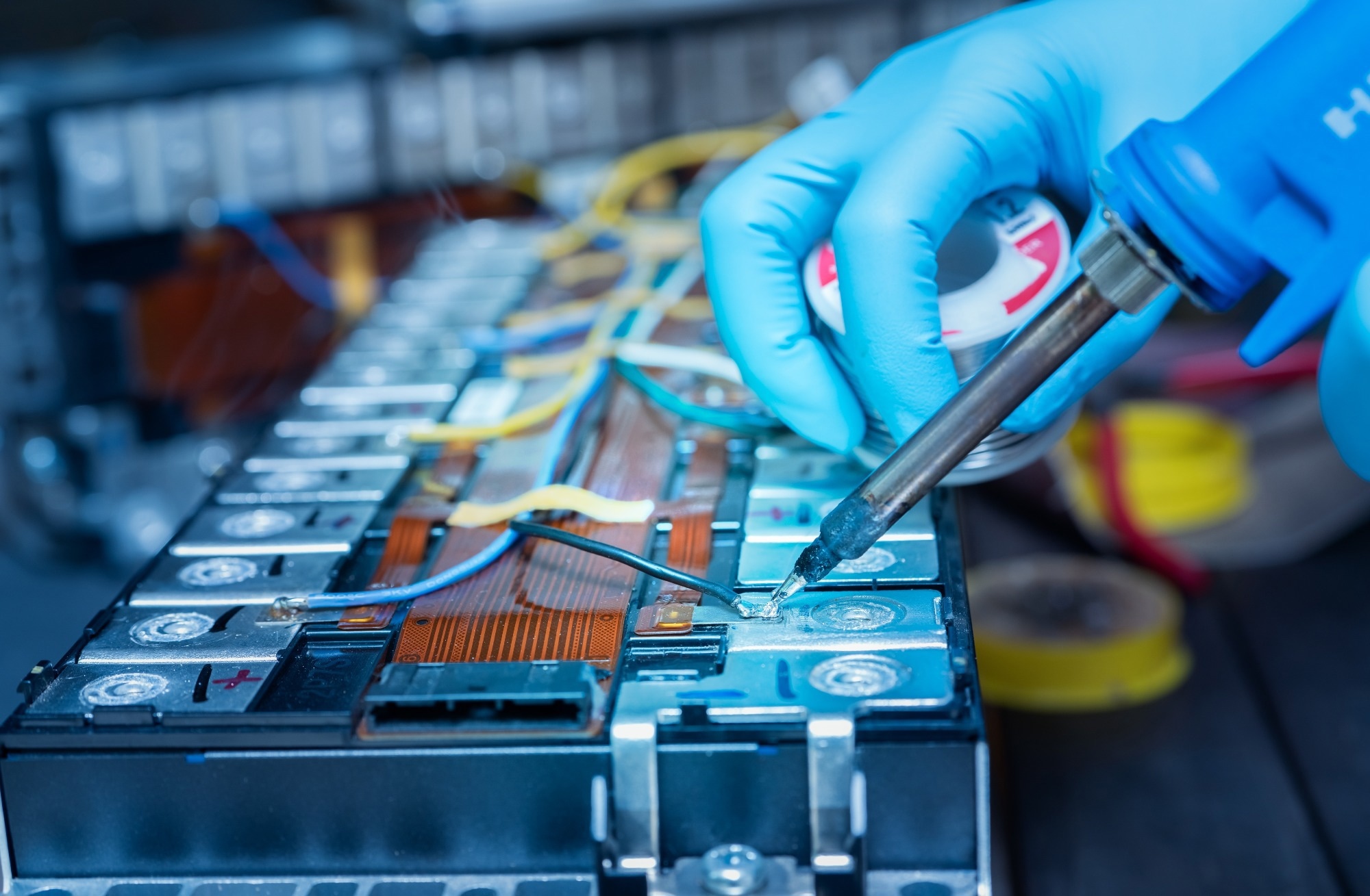 Technician use soldering iron to solder metal and wire of lithium-ion rechargeable battery