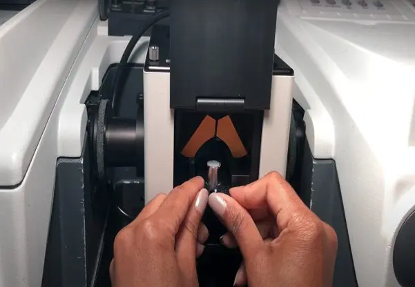 Loading the Sample Cup, containing a properly prepared sample, into the Praying Mantis Diffuse Reflection Accessory