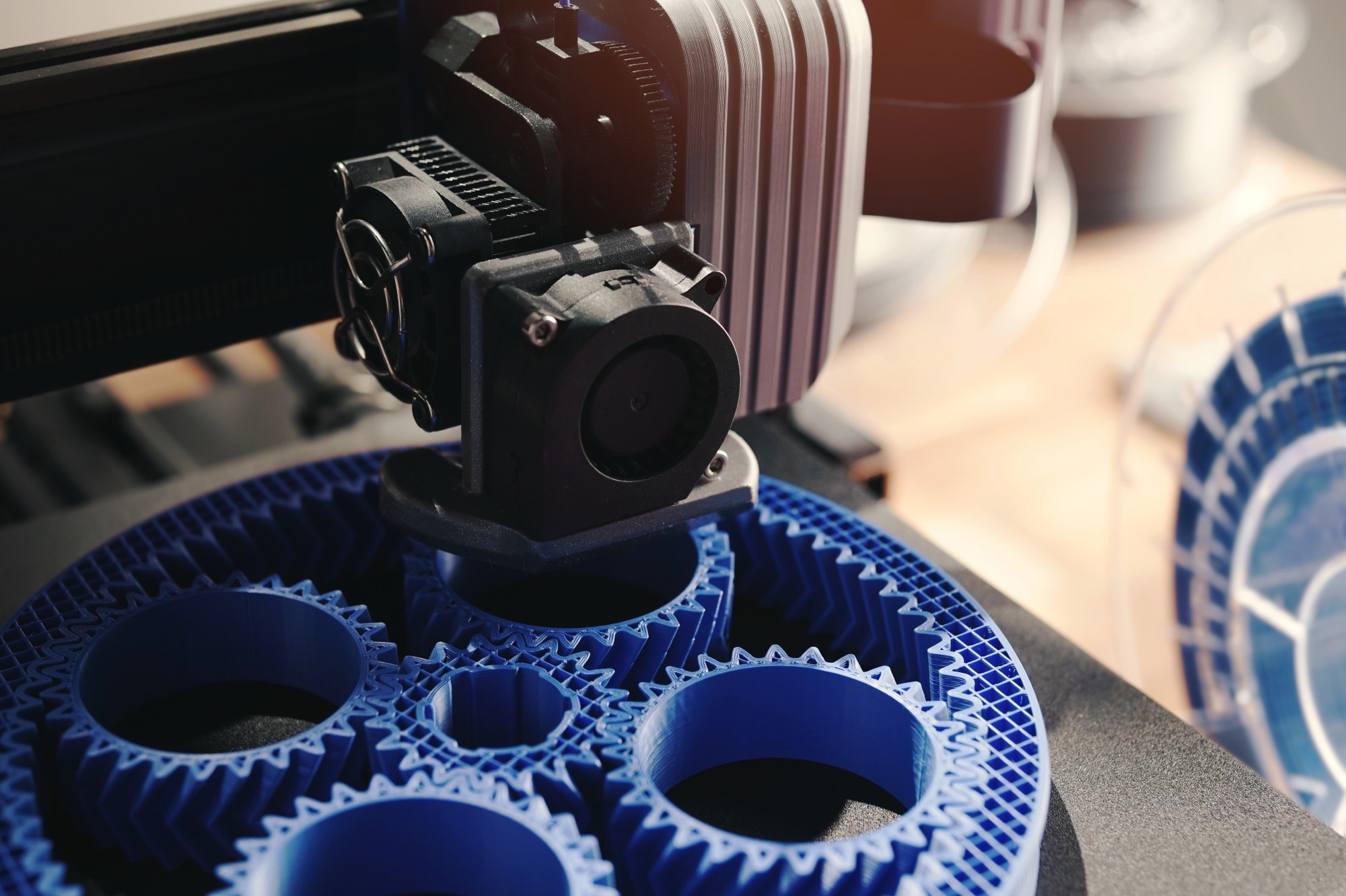 3D printer manufacturing cogs for mechanical parts.
