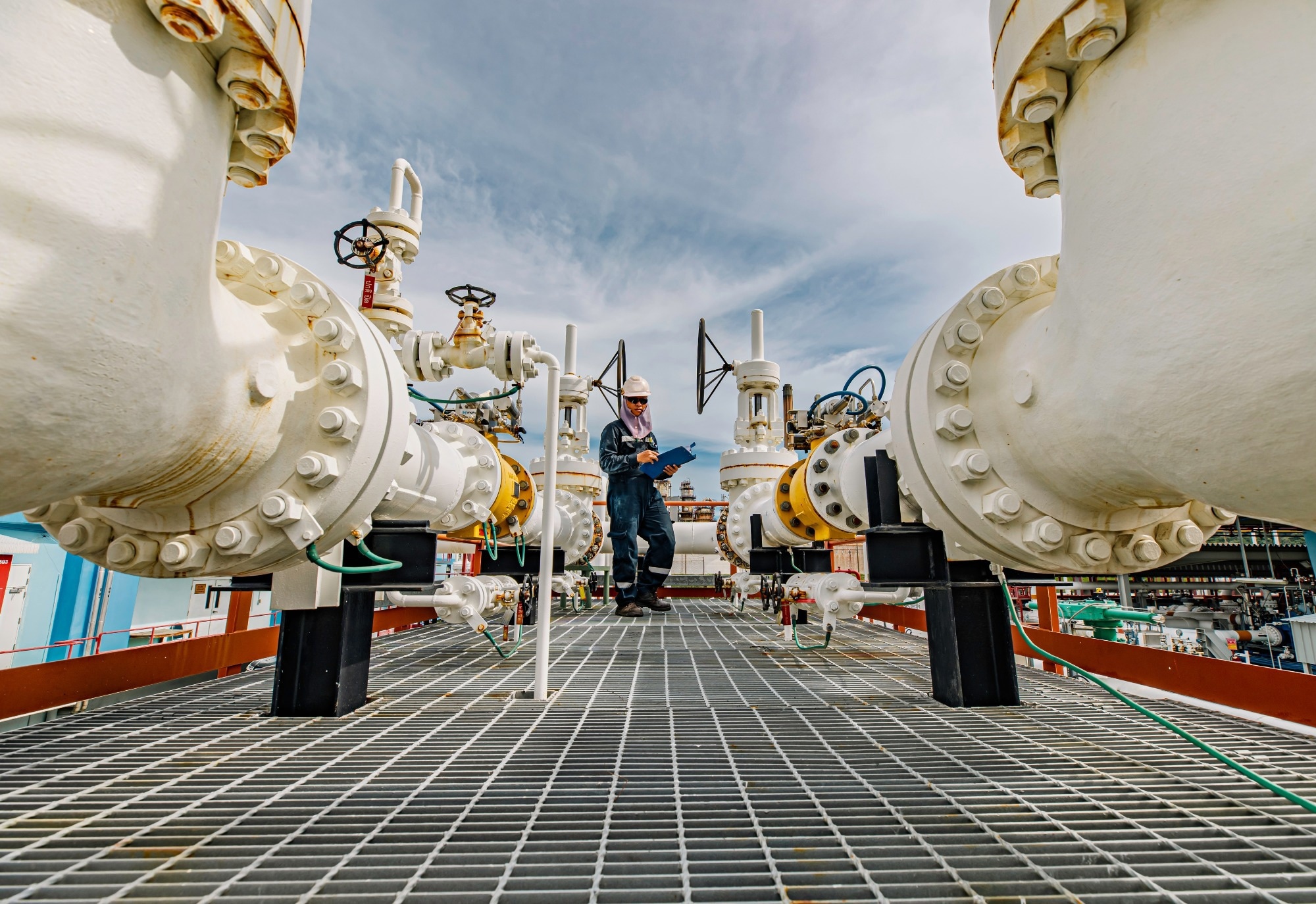 Male worker inspection at steel long pipes and pipe elbow in station oil factory during refinery valve of visual check record pipeline tank oil and gas