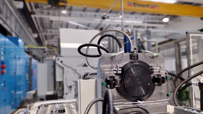 Industrial machinery with a large white casing, marked "ABB," featuring controls and components in a modern manufacturing facility.