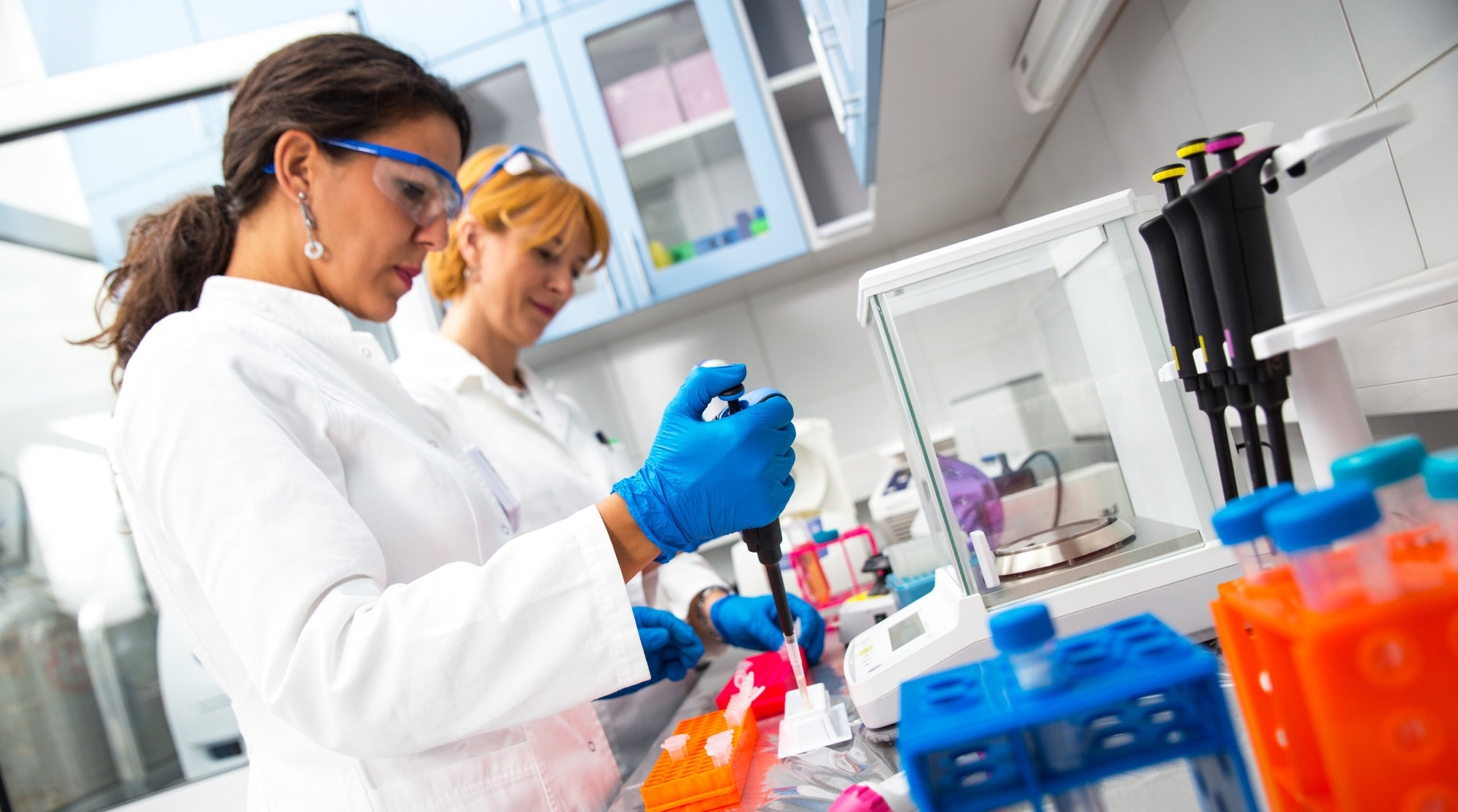 Scientists pipette samples into vials for testing.