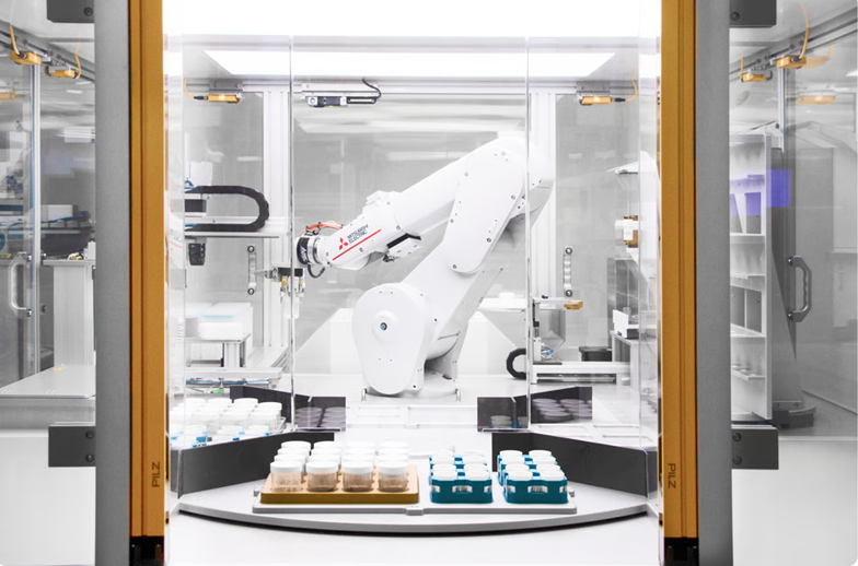 A robot arm carries samples around the system allowing for parallel processing.