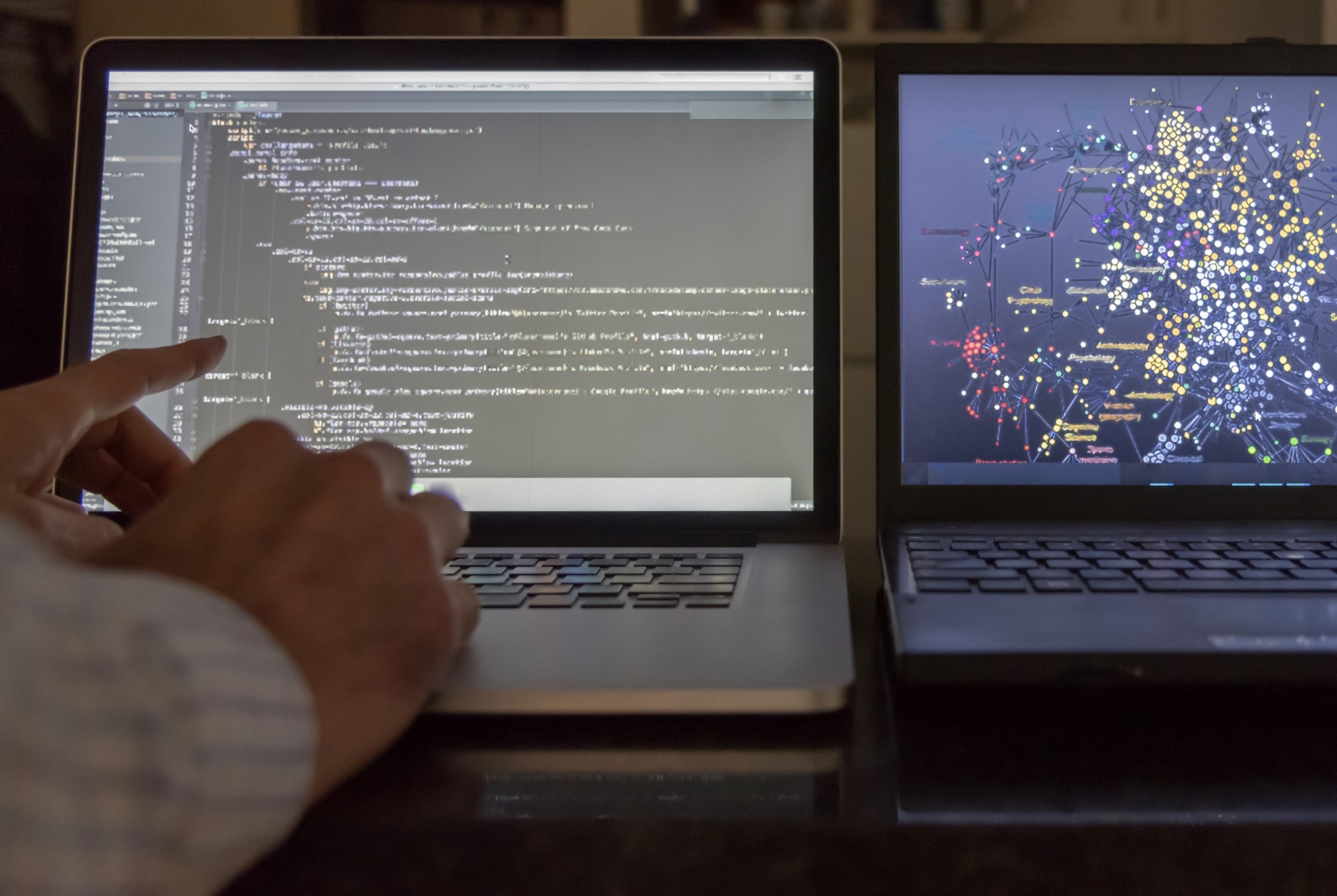 Computer scientist pointing at code screen with algorithmic data.