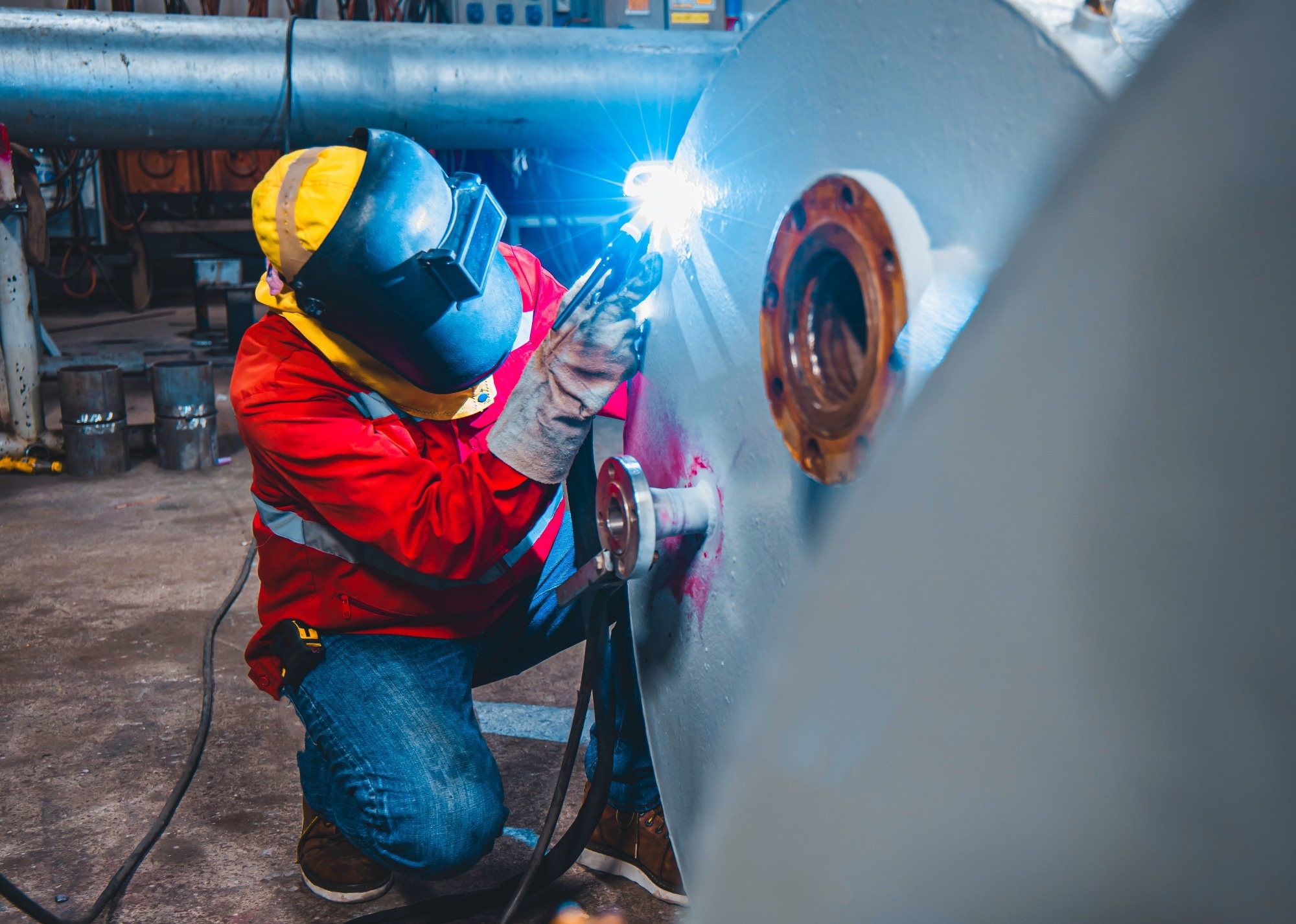 A person wearing protective clothing welds a section to be used in aerospace.