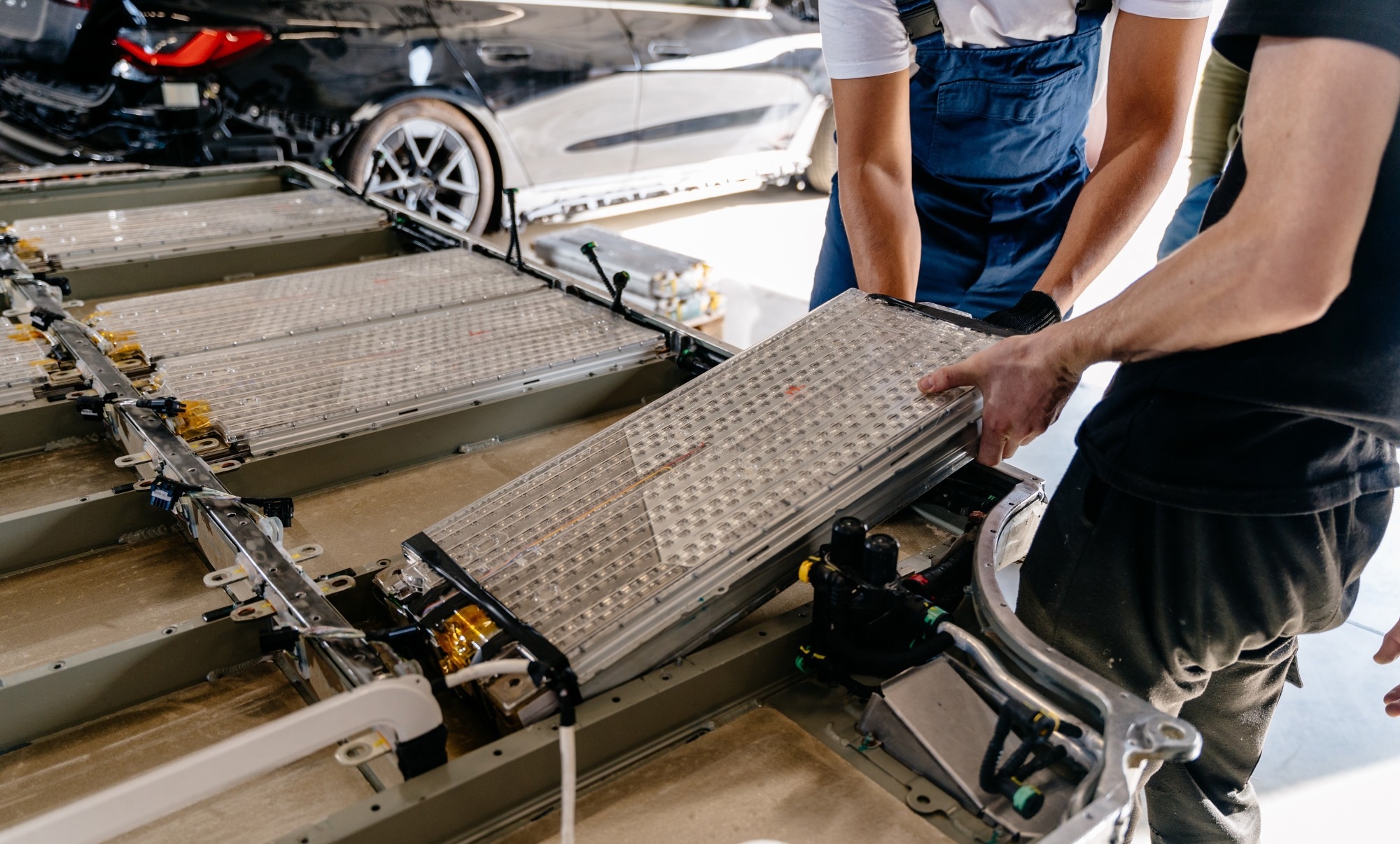 Assembly of an electric vehicle battery after repair in vehicle repair shop workshop indoor.