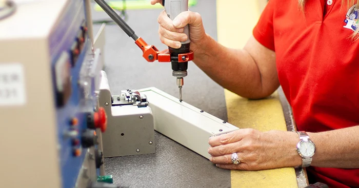 An Interpower employee making a customized component.