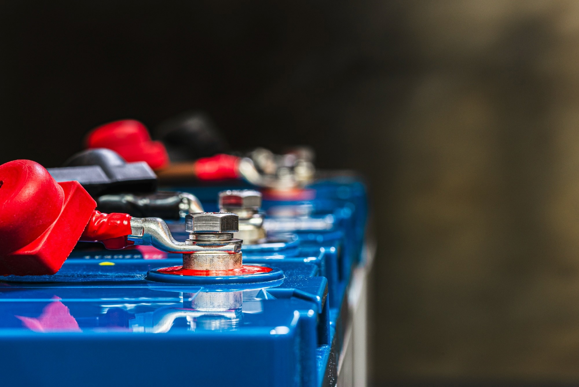 Battery terminal connected in a battery string inside a telecommunication facility, showing electrical cables, metal contacts, and technical infrastructure for backup power and energy storage.