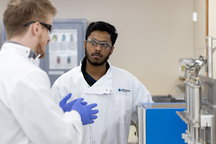 Two Micropore employees talking together by an instrument.
