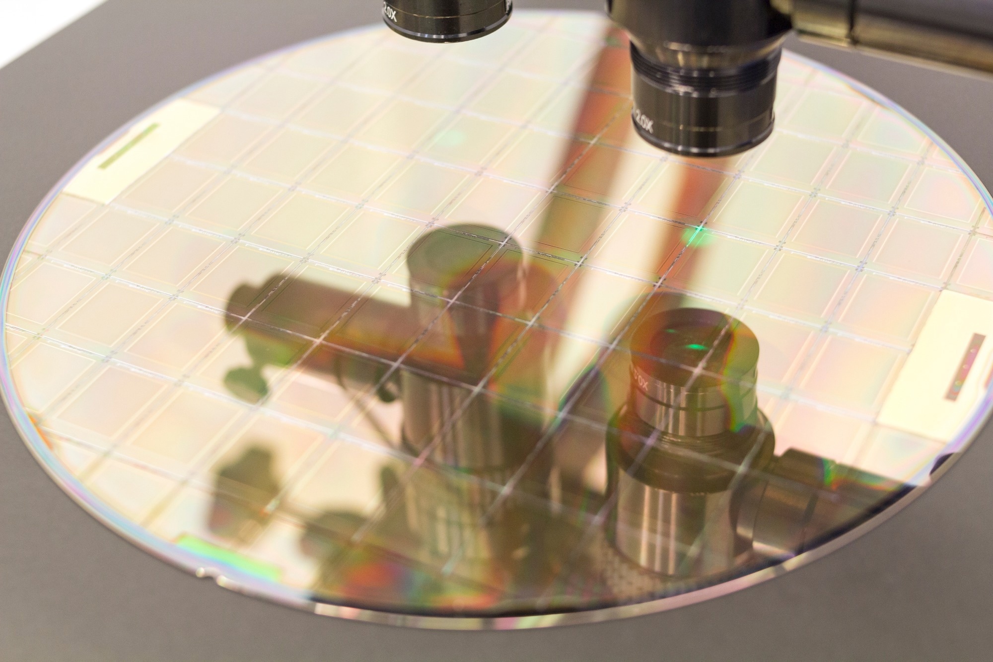 Silicon wafer on machine process examining in microscope.