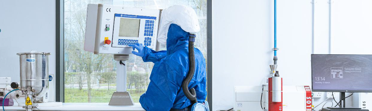A scientist wearing PPE using Hosokawa Micron equipment