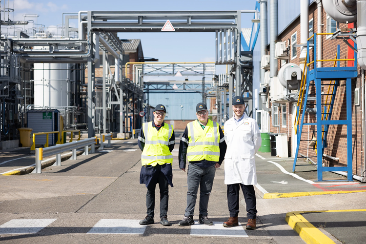Three male engineers smiling at camera