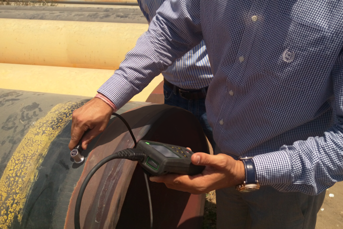 Man performing ultrasonic thickness assessment