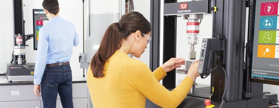 Female scientist using Instron equipment