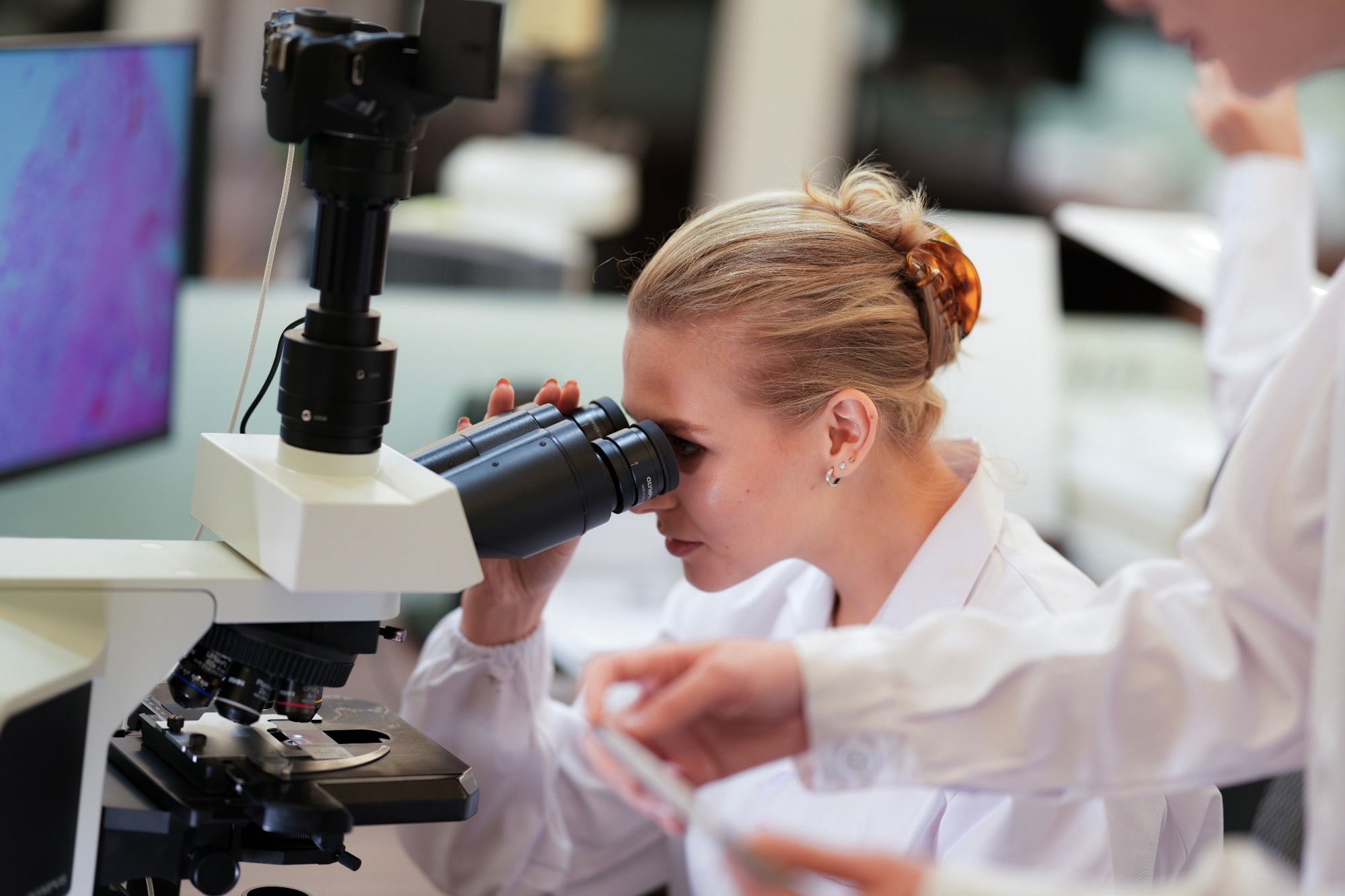 A biotech engineer uses an advanced digital microscope with AI powered image analysis to observe cellular changes in real time, pioneering new gene therapies or designing novel biomaterials.