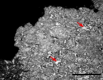 Photomicrograph of pro-eutectoid ferrite, arrows, in a cracked Grade P110 coupling.