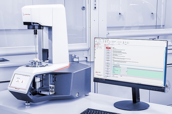 The rheometer sits next to a screen on a lab tabletop.